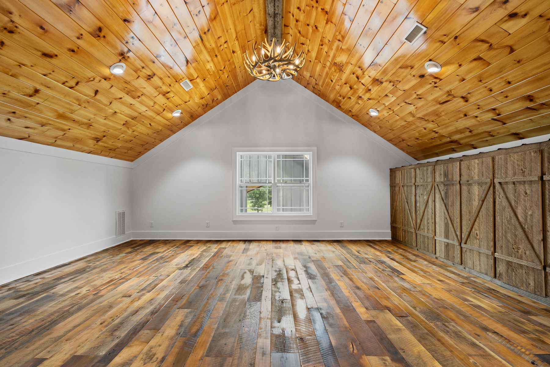 Vaulted pine ceiling and reclaimed wood floor in a new build